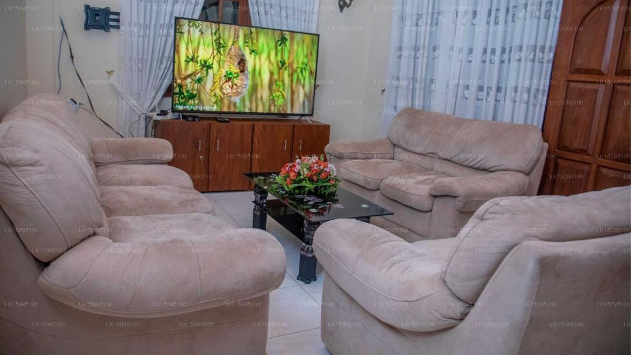 Living room with beige sofas and a television displaying a nature scene.
