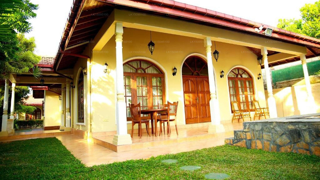 Traditional-style house with a veranda, dining area, and garden.