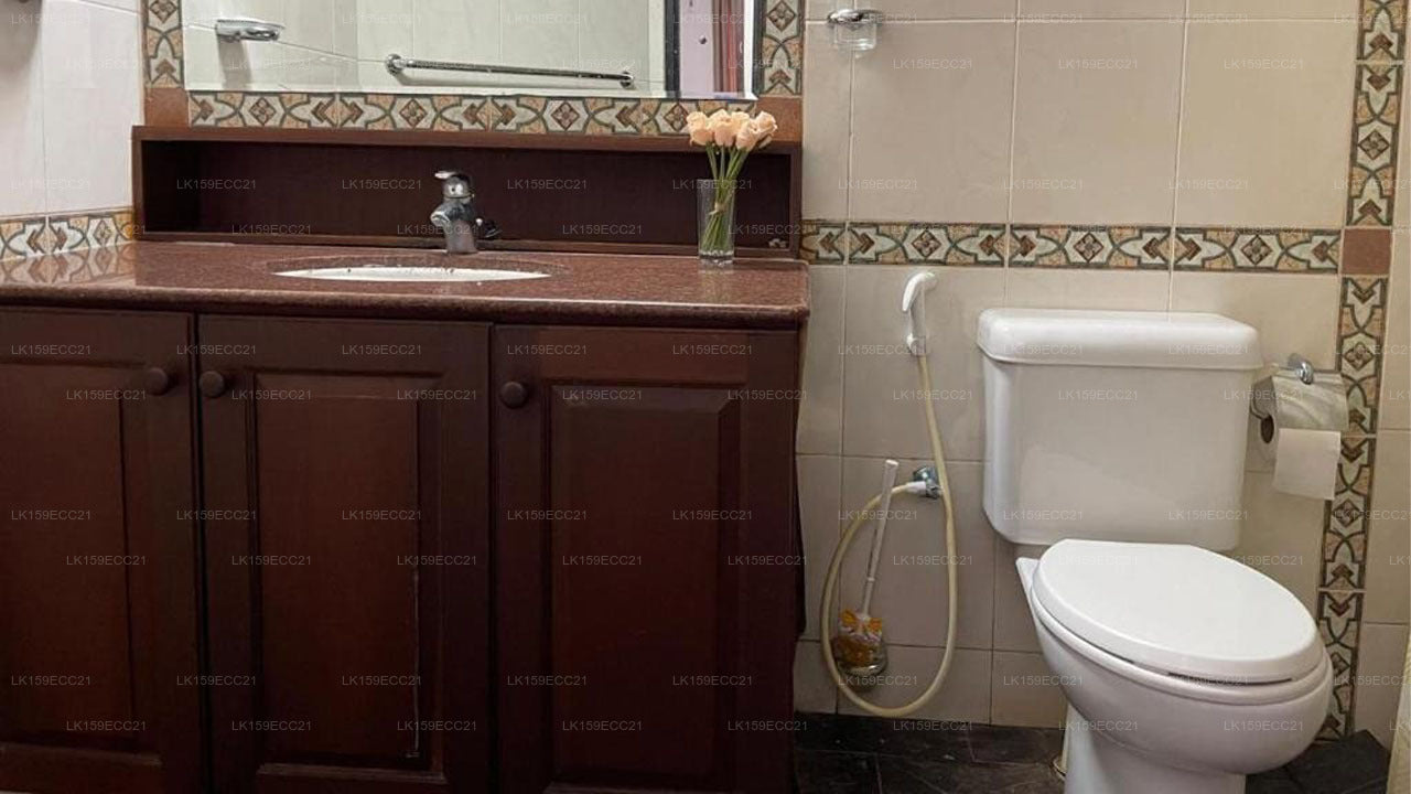 Bathroom with wooden vanity, sink, and toilet.
