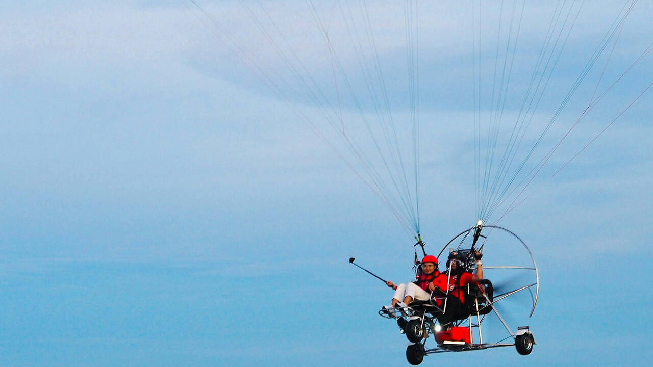 Person paragliding against a clear blue sky
